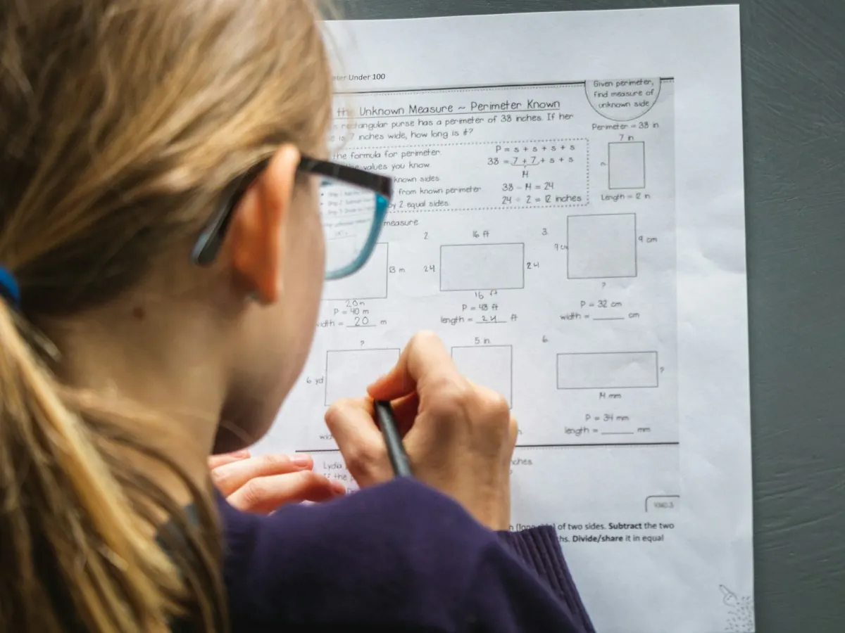 A girl in glasses working through a geometry worksheet